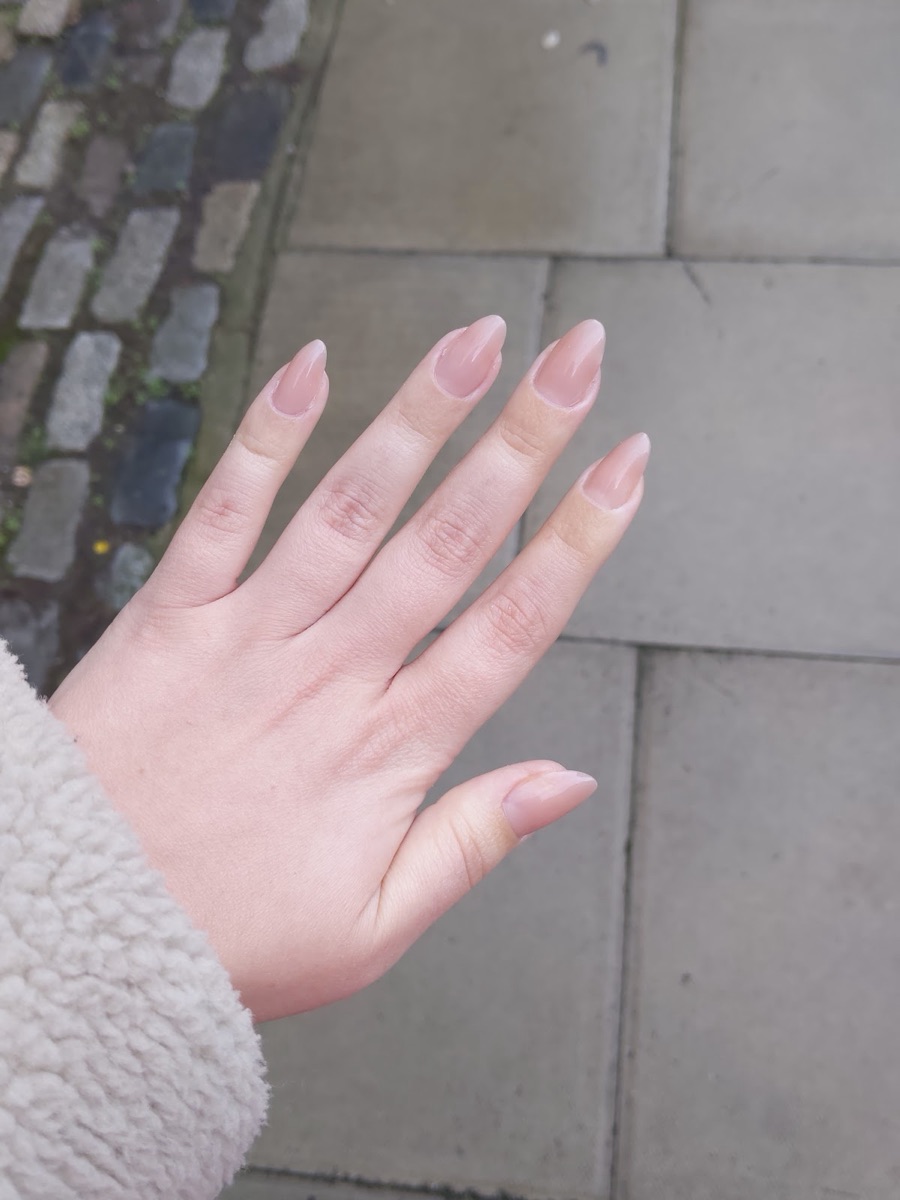 Glossy nude almond nails on a natural, understated set